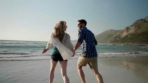 Couple running into ocean together Video stock 93311294