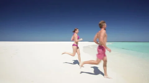 Couple running into waves Stock Footage 1017095