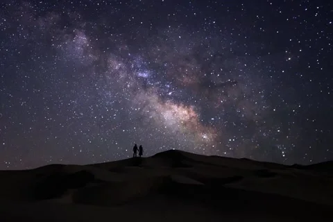 Couple on the Sand Dunes while the Milky Way Passes Overhead Stock Footage 239566456