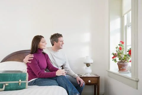 Couple sat on a bed Stock Photos