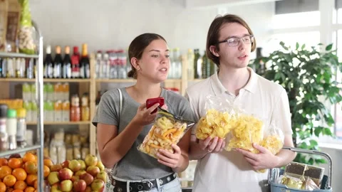 Couple scans the QR code on crispy snacks and potato chips , reads information Video stock 332638004