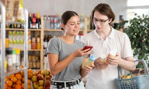 Couple scans the QR code on the packaging with sauces and reads information Stock Photos