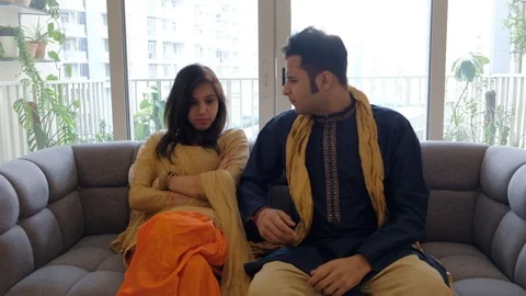 Couple seated at home while the man points his finger around showing her a varie Stock Footage 100631248