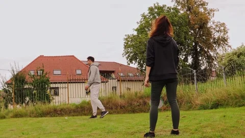 A couple is seen having fun as they learn to play badminton in their backyard Stock Footage 316806921