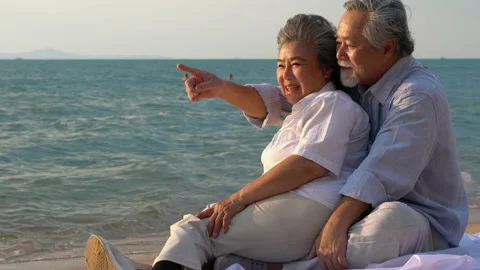 Couple senior sitting on the beach Stock Footage 183973907