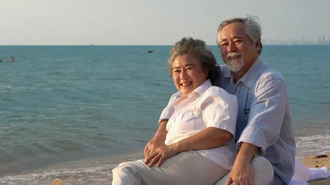 Couple senior sitting on the beach Stock Footage 183974054