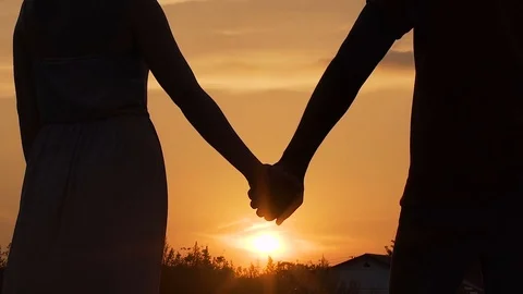 Couple separating their hands at sunset, love story ending, family break-up Stock Footage