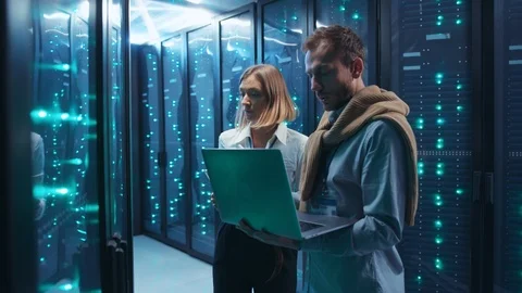 Couple of server engineers cooperating in high tech data center. Male and female 库存影片 119975601
