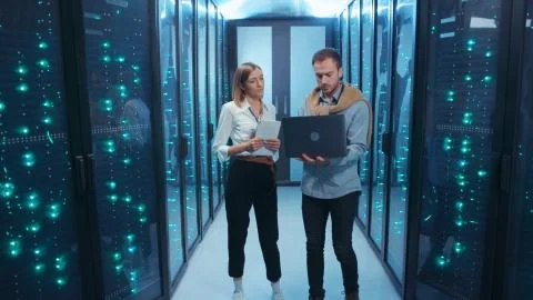 Couple of server engineers cooperating in high tech data center. Male and female Stock Photos