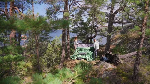 Couple setting up green tent in forest Stock Footage 331849169