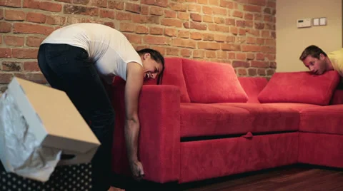 Couple setting a sofa in their new flat Stock Footage 33737194