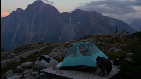 Couple Setting Up Tent and Embracing in Mountain Landscape at Dusk Stock Footage 327154157