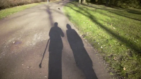 Couple shadow walking in spring park Stock Footage