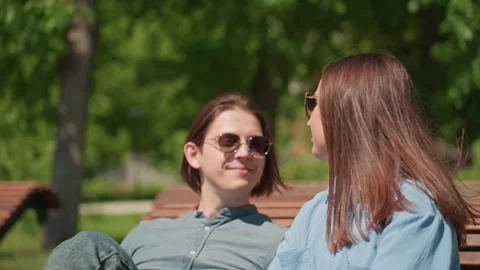 Couple sharing affection, lovers exchange kisses beneath vibrant trees, two Stock Footage 323322111