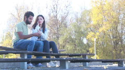 Couple sharing earphones while listening to music at park Video stock 59555243