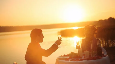 Couple sharing romantic sunset dinner on the beach Stock Footage