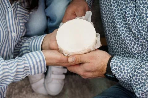A Couple Sharing a Round Cake During a Cozy Gathering Stock Photos