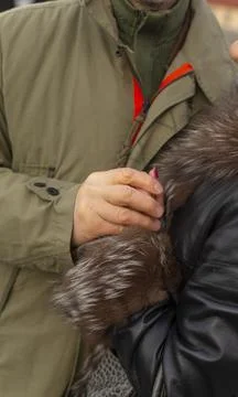 Couple sharing supportive hug under winter coats during peaceful town visit Stock Photos