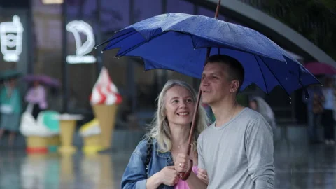A Couple Sharing an Umbrella While Enjoying the Rain Together on a Cozy Urban Stock Footage 289602115