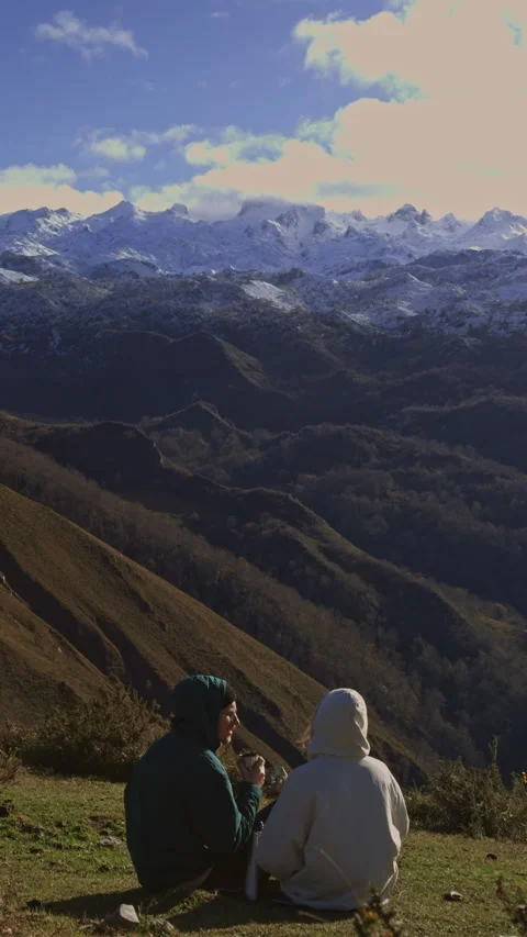 Couple sharing warm drinks during mountain picnic adventure. 스톡 동영상 337718825