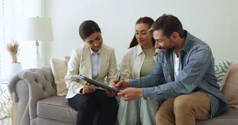 Couple signing purchase agreement finalizing paperwork with real estate agent Stockbeeldmateriaal 271118546