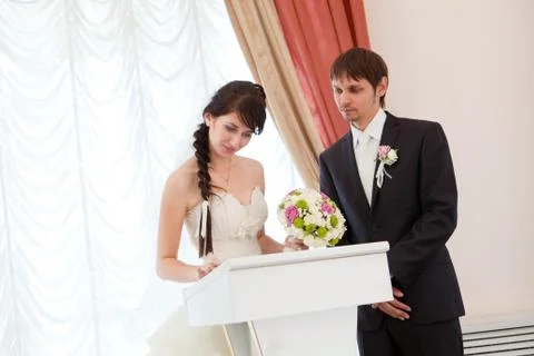 Couple signing a wedding document Stock Photos