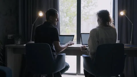 Couple in silhouettes working opposite window Stock Footage 260785169