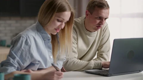 Couple sit on couch do paperwork pay bills use laptop e-bank app, manage finance Stock Footage 153274587