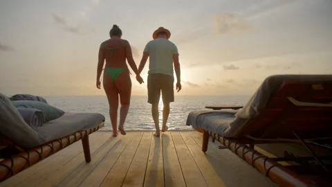 Couple sit down at sunset in Luxury Vacation Villa Stock Footage 247286772