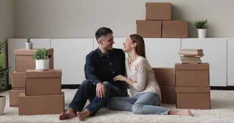 Couple sit on floor resting at relocation day near boxes Stock Footage 156698746