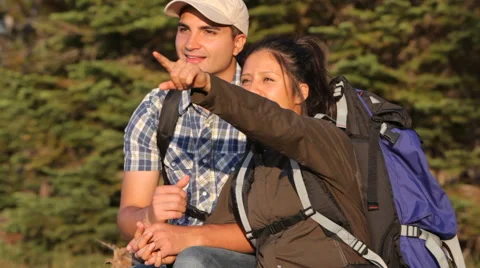 Couple sit looking out at mountains and lake Stock-Footage 61669826
