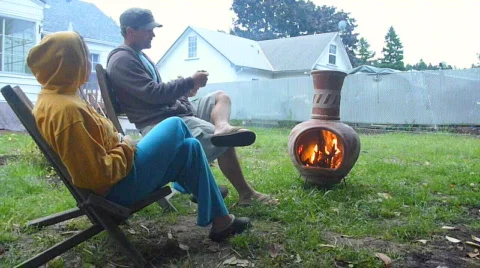 Couple Sit By Outside Fire Stock Footage 736256