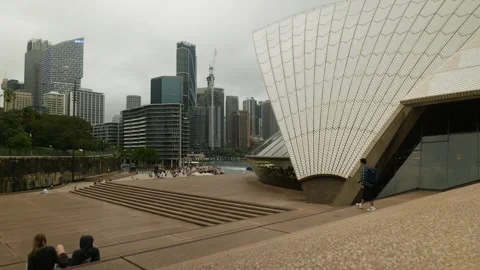 A couple sit on steaps at Sydney Opera House and chat 6K Video stock 302158119