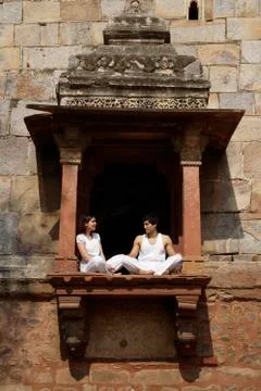 Couple sitting in ancient monument Stock Photos