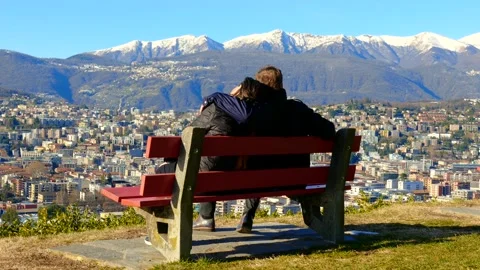 Couple Sitting and Hugging on a Bench and Walking Away with Snowcapped Mountain Vídeos de archivo 194011848