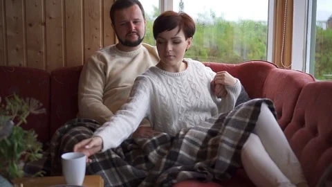 Couple sitting and hugging on sofa at home Stock Footage 119367168