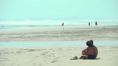 Couple Sitting and Talking on Beach Sand Stock Footage 48918358