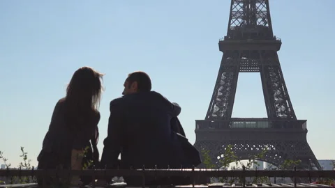 Couple sitting and talking in front of Eiffel Tower Paris Stock Footage 263991372
