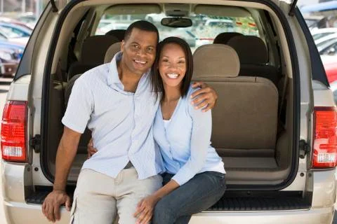 Couple sitting in back of van smiling Stock Photos