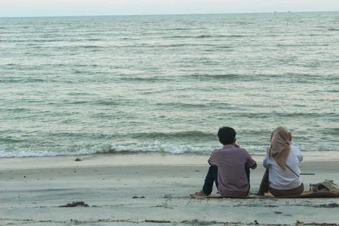 A couple sitting on the beach Foto stock