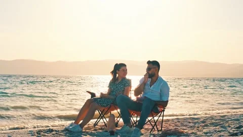 Couple Sitting on Beach at Sunset | Stock Video | Pond5