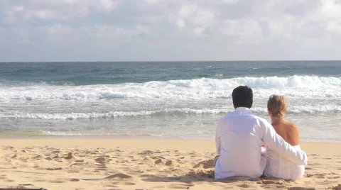 Couple Sitting on Beach Watching the Waves Stock Footage 1044912