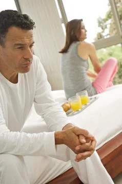 Couple sitting on bed, indoors Stock Photos