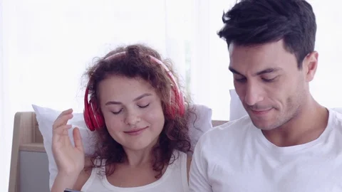 Couple sitting on the bed. Man and woman watching to a laptop. Видео 107736072