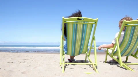 Couple sitting in chairs at beach Stock Footage 62280059
