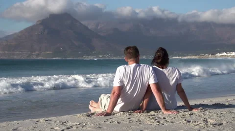 Couple sitting close together on beach and enjoying the view Stock Footage 51170596