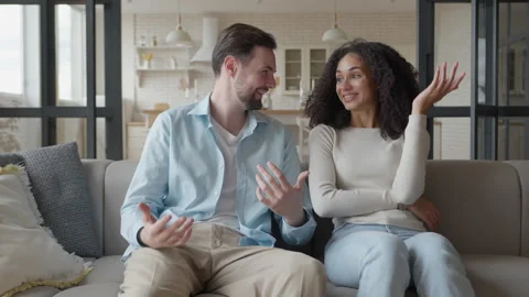 Couple Sitting On Couch Chatting And Smiling Warmly In Cozy Modern Living Room Stock Footage 306695589
