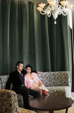 Couple Sitting On Couch In Hotel Lobby Stock Photos