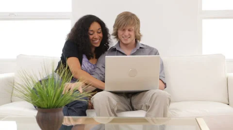 Couple sitting on couch with laptop computer Stock Footage 32716383