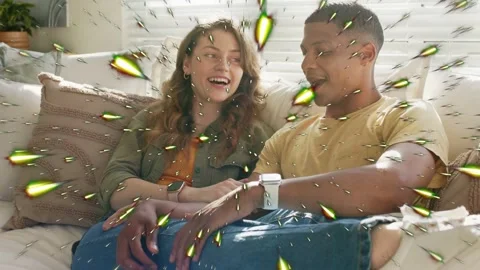 Couple sitting couch man sharing health tip causing glow sparks drifting over Vídeo Stock 333485519